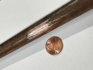 Image of a brown copper pipe. When scratched, it will shine like a new penny.